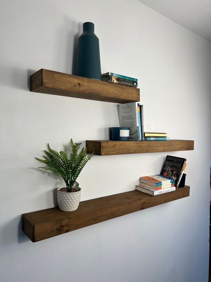 Floating shelf with tempered glass top, chrome metal brackets, sleek finish, living‑room accent